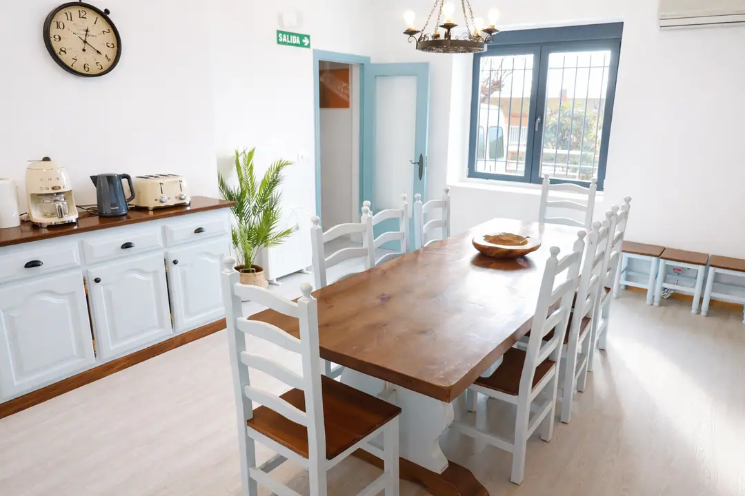 Mesa de comedor junto al aparador con cafetera, hervidor y tostadora