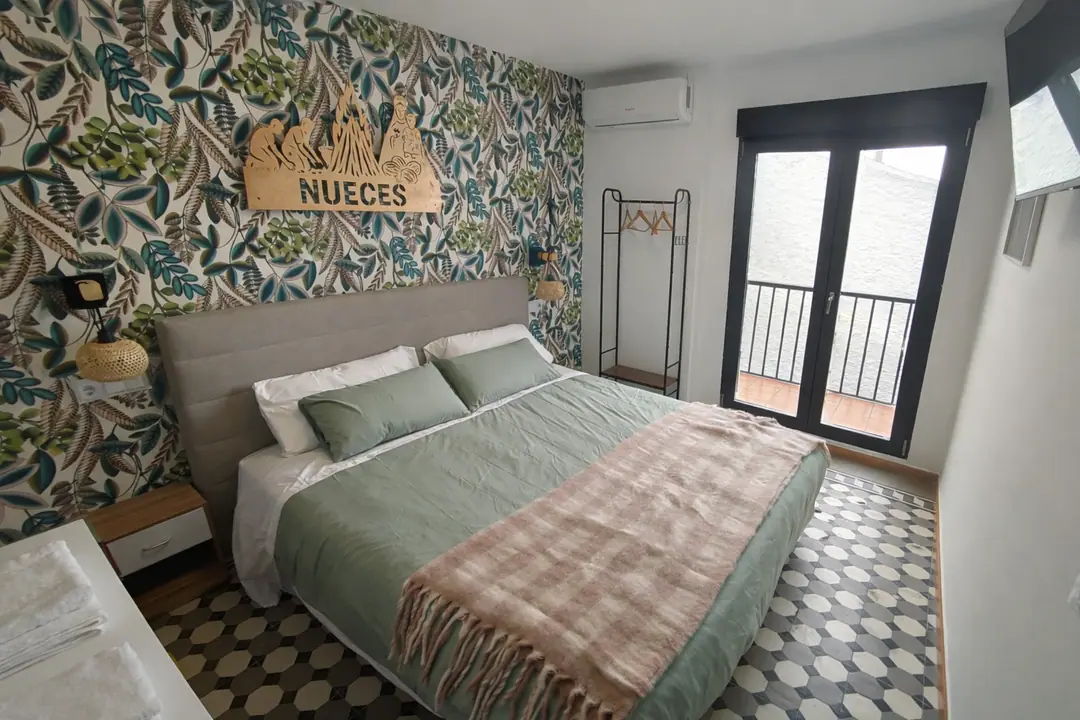 Habitación Nueces con cabecero vegetal, televisión y balcón